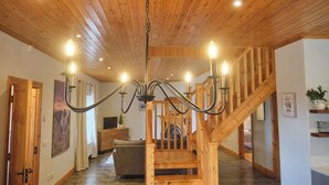 Un intérieur en bois avec un escalier, un lustre et un canapé.