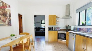 A compact kitchen with wooden cabinets, a dishwasher, and a tiled backsplash. - 4BR Workers Accommodation | Sleeps 7 | Wi-Fi (Letterkenny)
