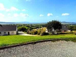 A rural landscape with houses, a gravel path, and a grassy field. - Stunning Sea Views, Pets Welcome, Sleeps 9 (Carraig Airt)
