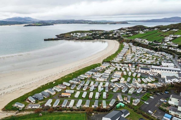 A coastal area with a beach and a row of mobile homes.