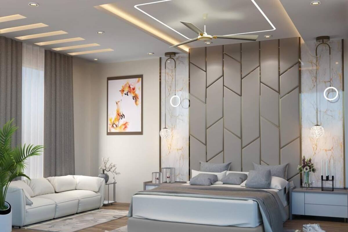 A modern bedroom with a bed, a sofa, a ceiling fan, and wall-mounted lighting.