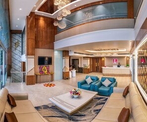 A spacious lobby with a reception desk, seating area, and a television. - Lords Inn Sangam (Bhopal)