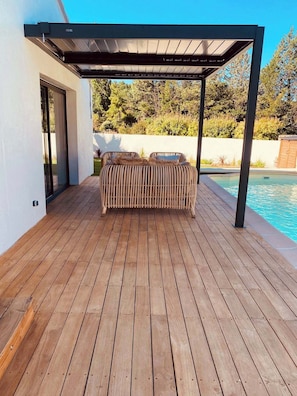 Un área de estar al aire libre con techo y piscina.