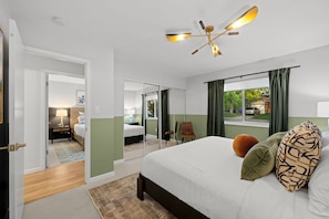 Une chambre d’hôtel avec un grand lit, un ventilateur de plafond, une fenêtre avec des rideaux et une vue sur l’extérieur.