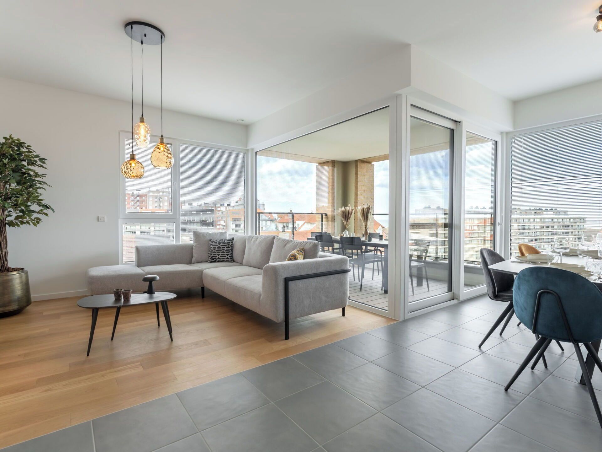 Un salon moderne avec un canapé, une table basse et un coin repas avec des chaises.