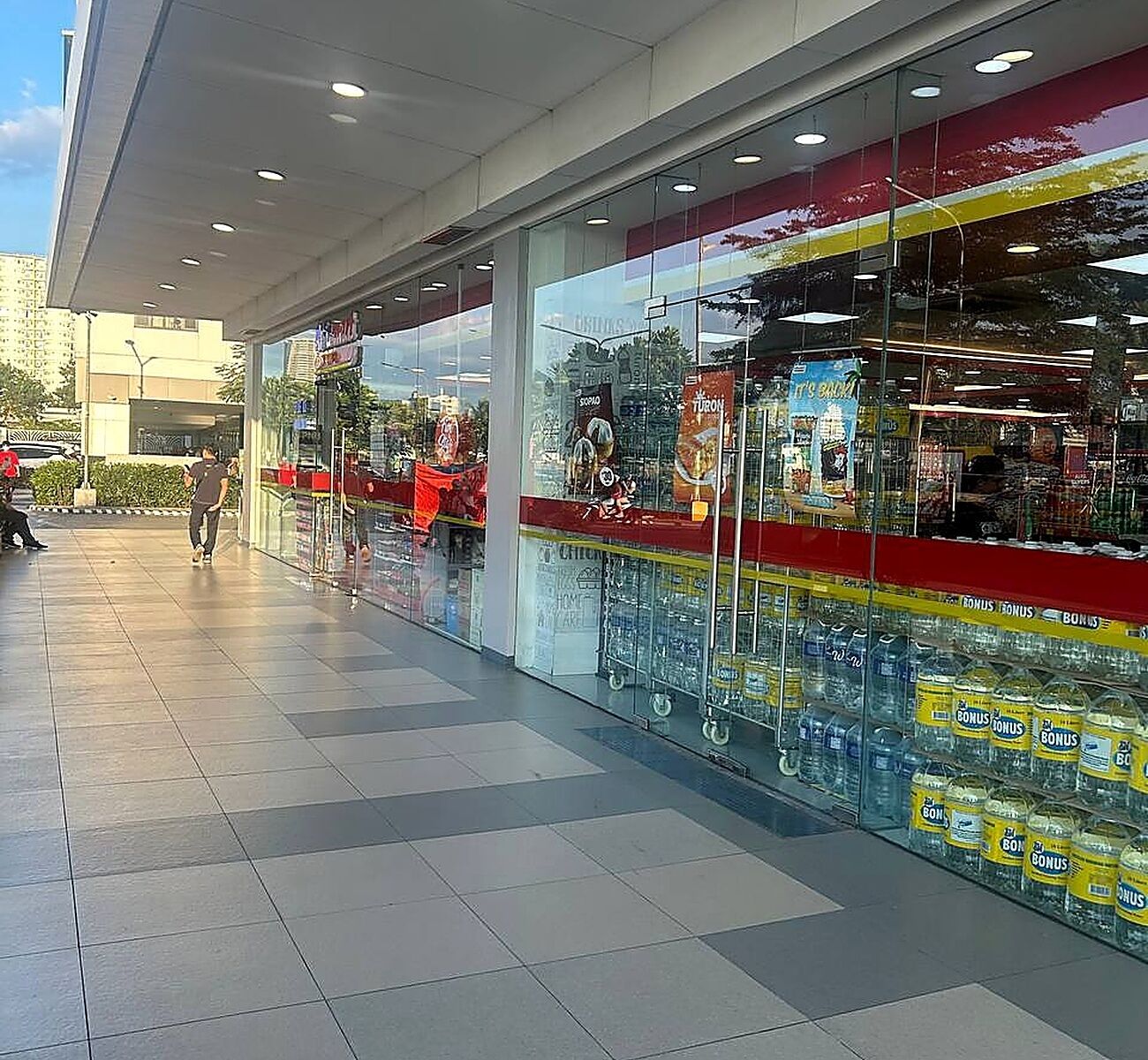 A store with large glass windows displaying products and promotional signs.