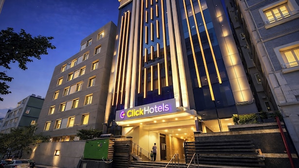 A Click Hotels building with a modern facade, multiple floors, and a staircase leading to the entrance. - Click Hotel Gachibowli Hyderabad (Hyderabad)