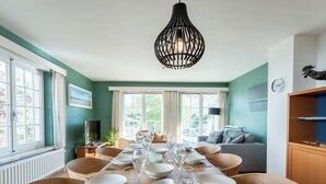 Comedor con mesa de madera dispuesta para una comida, rodeado de sillas.