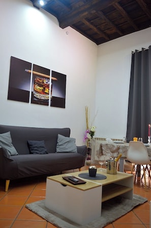 Een woonkamer met een bank, salontafel en een schilderij aan de muur.