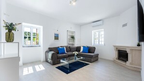 A spacious living room with a sofa, a glass coffee table, a fireplace, and a TV. - Casa do Vale - in Paderne (Paderne)