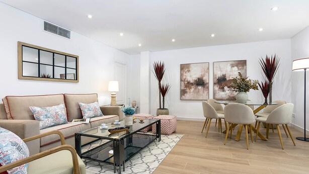 A modern living room with a sofa, coffee table, dining table, chairs, and decorative plants. - Luxury Apartment in Cordoba Center. Plaza Doblas (Córdoba)