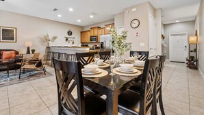 A modern kitchen with wooden cabinets, a microwave, and a refrigerator.