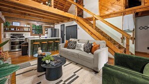 A spacious living area with a wooden staircase, a kitchen, and a dining area. - Gimme the Smokies, 2 BR, 2 BA, Sleeps 6 (Townsend)