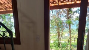 A staircase leading to a covered outdoor area with a view of greenery and a tiled floor. - Colibri Chalet in Vale do Capão, Chapada Diamantina, Bahia, with panoramic views. (Caeté-Açu)