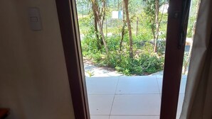 An entrance with a bench, a tiled floor, and a view of a garden through the doorway. - Colibri Chalet in Vale do Capão, Chapada Diamantina, Bahia, with panoramic views. (Caeté-Açu)
