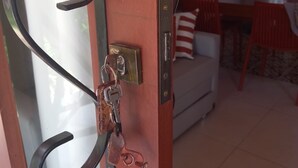 A door with a metal handle, a keyhole, and a keychain with keys. - Colibri Chalet in Vale do Capão, Chapada Diamantina, Bahia, with panoramic views. (Caeté-Açu)