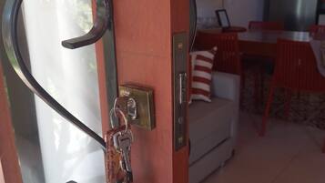 A door with a metal handle, a keyhole, and a keychain with keys.