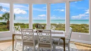 A dining area with a view of the ocean, white chairs, and a table. - 180 Degree Ocean Views Direct Access to Holmes Beach (Holmes Beach)