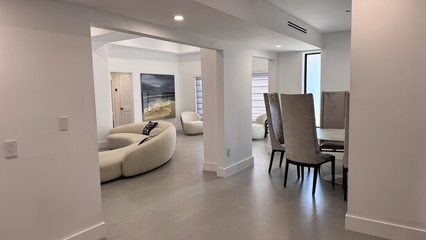 Ein modernes Interieur mit Essbereich, einer Couch und einem Gemälde an der Wand.