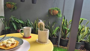 Un tavolo con un piatto di cibo, una tazza e una pianta in vaso.
