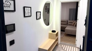 A modern hallway with a console table, a wall-mounted TV, and framed artwork.