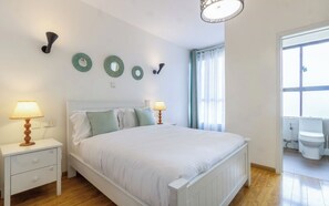 A bedroom with a bed, bedside tables, a window with curtains, and wall-mounted decor. - Luxurious 2 Bedroom Duplex Apartment in Kilimani, Nairobi (Nairobi)