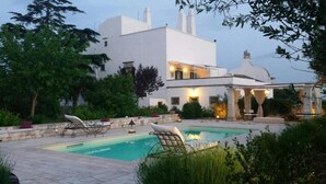 A modern house with a swimming pool, outdoor seating, and a garden. - Masseria Tagliente (Martina Franca)