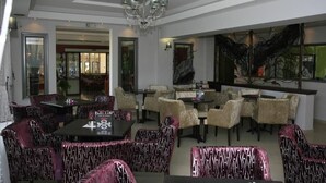 Un ristorante con sedie, tavoli e lampadari decorati.