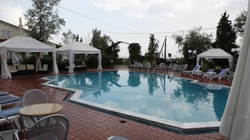 Una piscina al aire libre de temporada, sombrillas