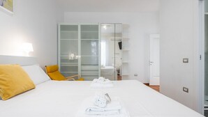 Habitación de hotel con cama, armario, baño y puerta.