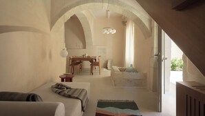 A cozy room with a bed, a dining table, and a view of the outdoors. - Moshoviti Residence (Rethymno)