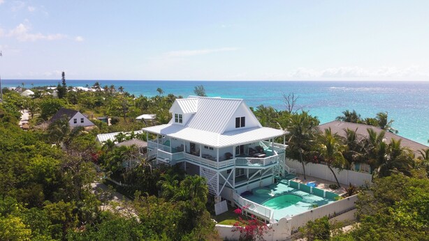 A large house with a pool and a view of the ocean.