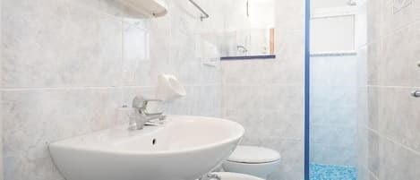 Un baño moderno con lavamanos, bidé y ducha.