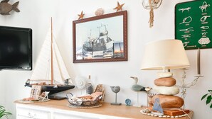 A nautical-themed room with a sailboat model, a framed photograph of a sailing ship, and a wall-mounted display of nautical items. - Apartment "Gîte Etienne Marie" with Private Terrace (Le Crotoy)