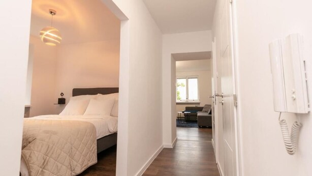 Ein Hotelzimmer mit Bett, Nachttisch, Lampe, Telefon und Blick auf den Speisesaal.