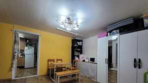 Une cuisine de taille réduite avec un coin repas, un plancher en bois et un ventilateur de plafond.