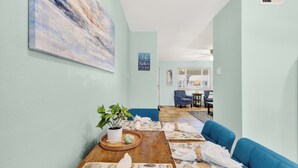 Ein Zimmer mit Holztisch, blauem Sofa und einem Gemälde an der Wand.