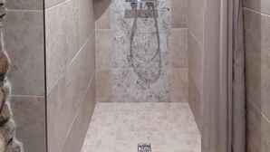 A shower with a glass door, a handheld showerhead, and a wall-mounted towel rack. - Charming bed and breakfast in an authentic Ardèche farmhouse. (Saint-Paul-le-Jeune)