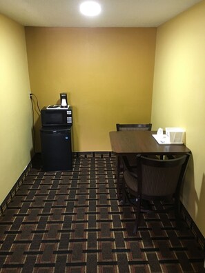 A small room with a table, chairs, a microwave, and a coffee maker. - Days Inn by Wyndham Orange City/deland (Orange City)