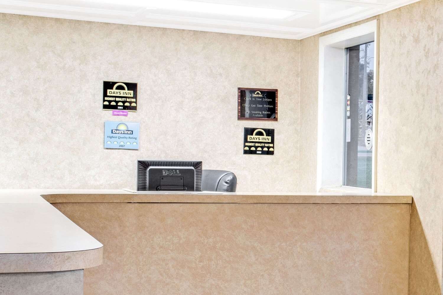 A reception desk with a computer, a window, and three awards for 'Highest Quality Rating' from different years.