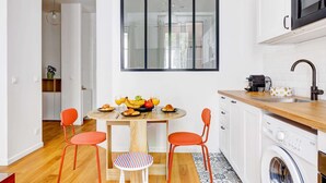 Une cuisine moderne équipée d’une table à manger préparée pour le petit-déjeuner, d’un lave-linge et d’un four à micro-ondes.