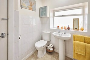 Un baño con inodoro, lavamanos y ventana.