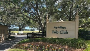 A sign for 'The Villages Polo Club' with a landscaped area in front. - Beautiful 3-bedroom house on private cul-de-sac with Golf Cart in The Villages (The Villages)
