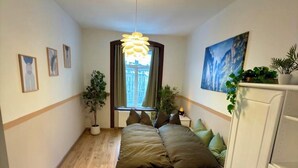 A bedroom with a bed, a wardrobe, a window with curtains, and a painting on the wall. - Görlitzer Zweisamkeitsquelle, Bezauberndes Wohnung mit ausgestatteter Küche (Görlitz)