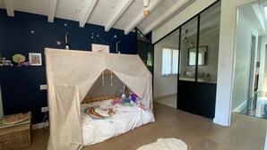 Un dormitorio con cama a dosel, alfombra blanca y techo decorado con estrellas.