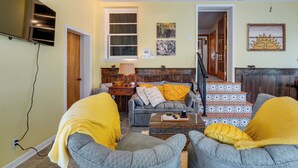 A living room with a sofa, two armchairs, a coffee table, and a staircase. - 1 Mi to Dtwn Tiffin! Brick Bungalow w/ Patio, Yard (Tiffin)