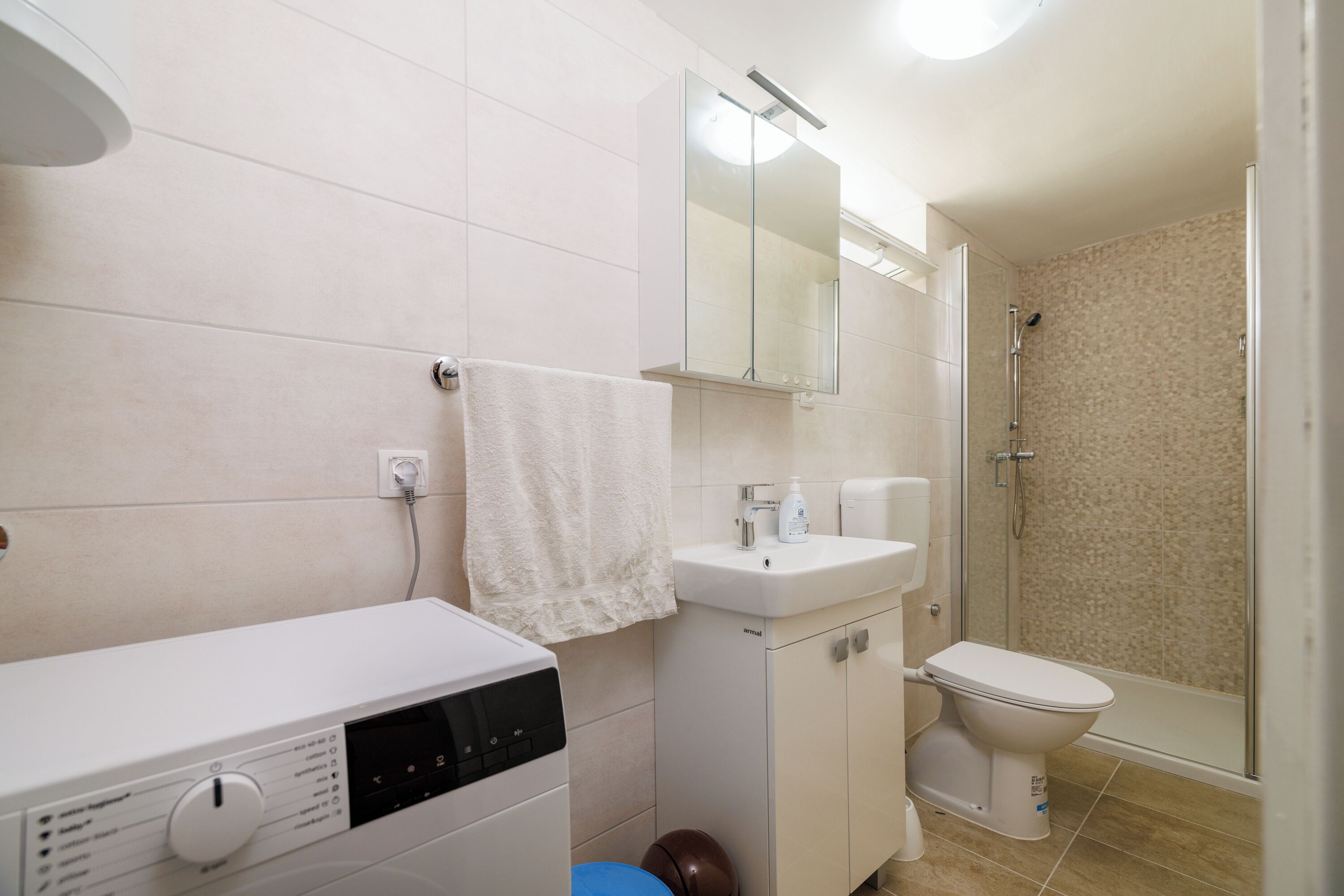 Een douche, handdoeken, zeep, toiletpapier