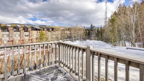 A balcony with a railing overlooking a snowy landscape, buildings in the background, and a clear sky. - Steps From Ski Shuttle! WP Condo w/ Heated Pool (Winter Park)