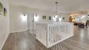 A spacious living area with a white railing, a dining table, and a staircase. - Steps From Ski Shuttle! WP Condo w/ Heated Pool (Winter Park)