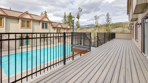 Ein Wohngebiet mit Schwimmbad, Holzdeck und Häusern mit ähnlicher Architektur.